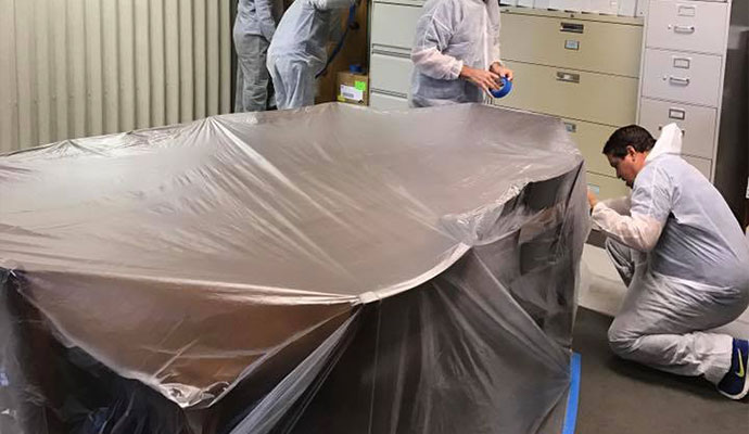 Professional team covering content with plastic sheet Professional team covering content with plastic sheet